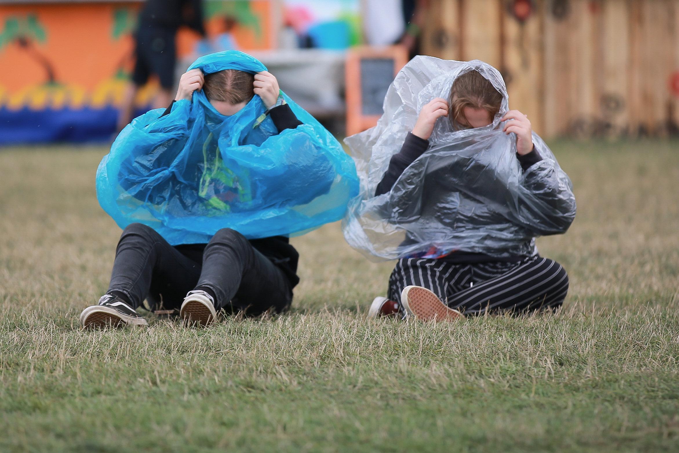 Посетители фестиваля пытались найти укрытие от сильного дождя на фестивале в Лидсе